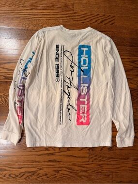 Hollister Men's White Long-Sleeve Graphic Tee with Blue-to-Pink Gradient Logo
